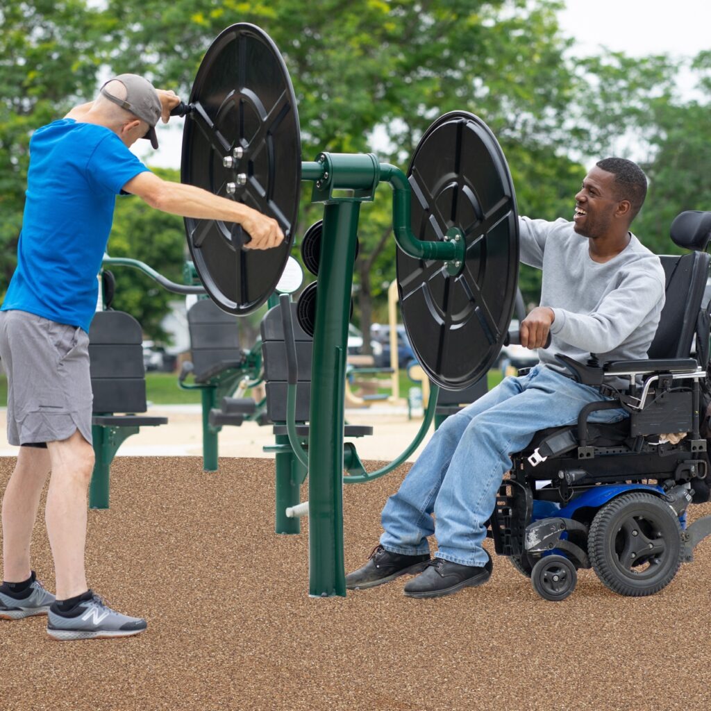 One man in a wheelchair and another man stretching on the 2-Person Accessible Shoulder Wheel