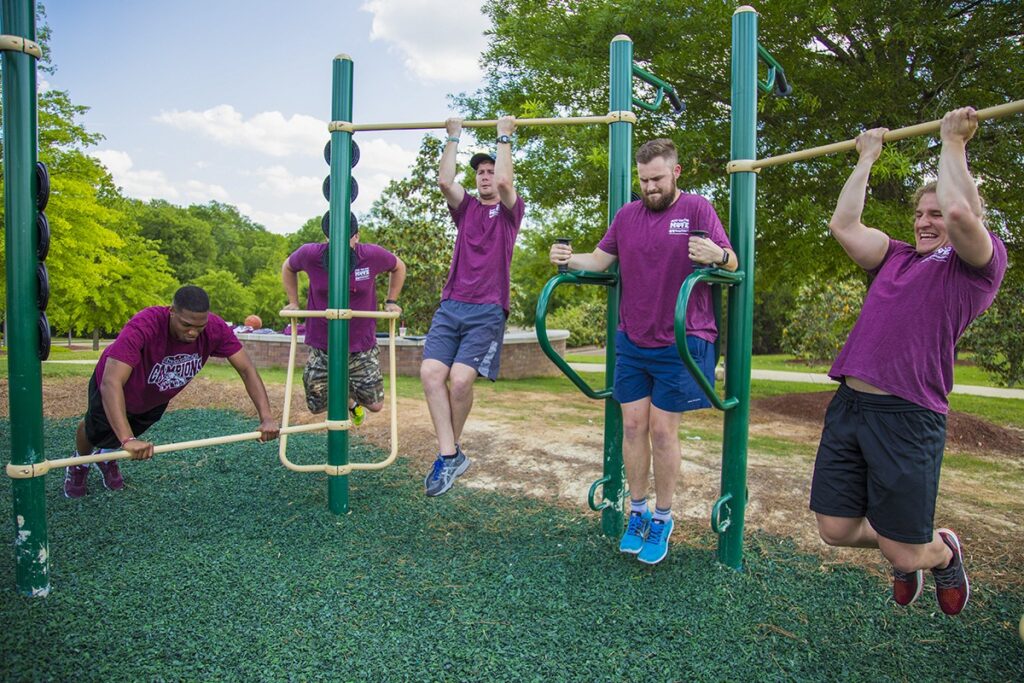 A group of students exercising on the 13-Person Cross Fitness Rig