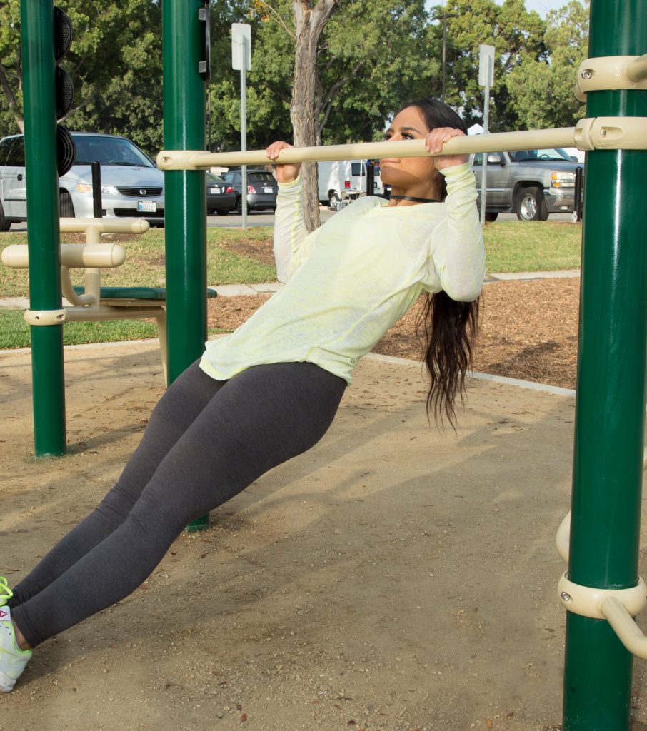A woman using assisted pull up bar