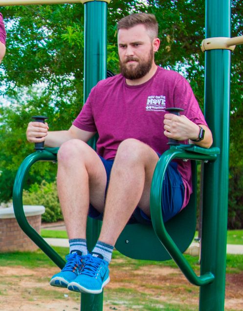 A man demonstrating knee lifts on captain's chair