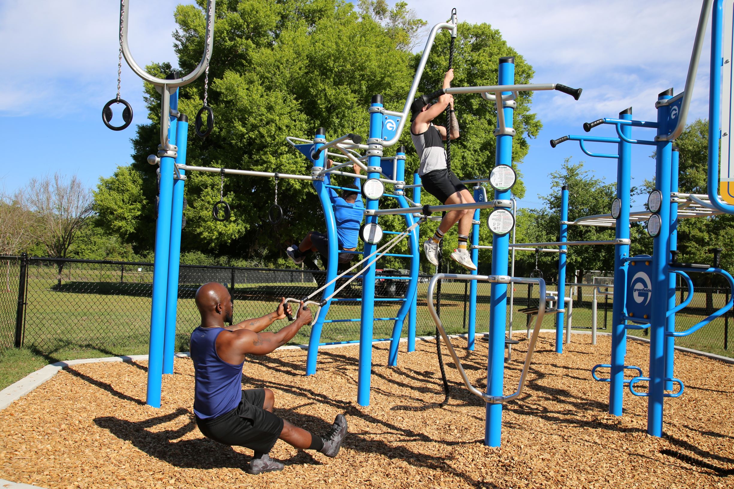 Two men exercising on a custom blue and silver rig.