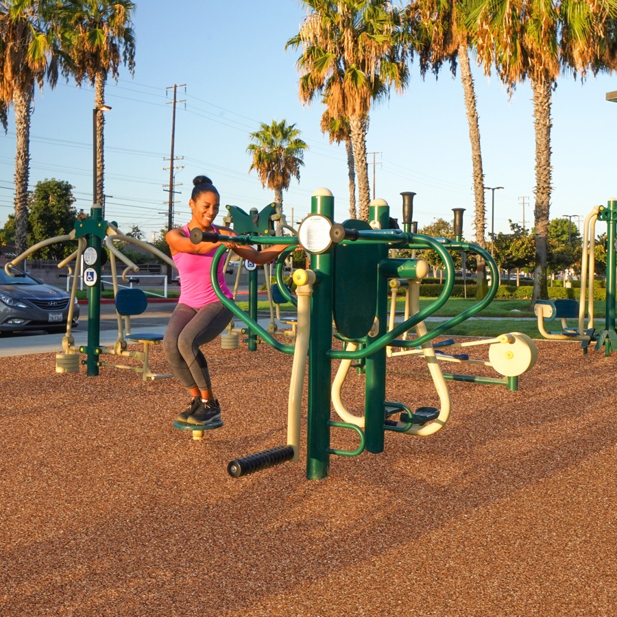 A woman exercising on the 4-Person Pendulum, Abs & Dips Station