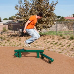 A man jumping over the 3-Beam Jump Bars