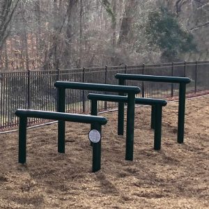 The Over and Under Bars with Engineered Wood Fiber surfacing with a fence and trees in the background