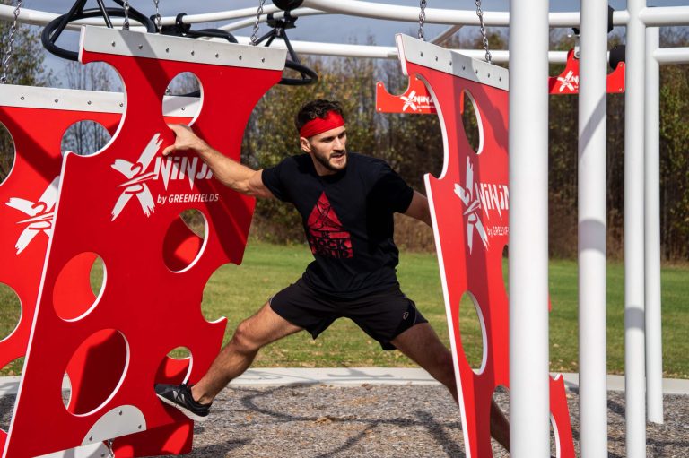 A man climbing Cheese Walls on an X-Treme Ninja Course