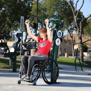 A woman in a wheelchair exercising on the Accessible Vertical Press