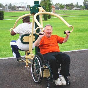 A man in a wheelchair and a woman using a wheelchair accessible vertical press